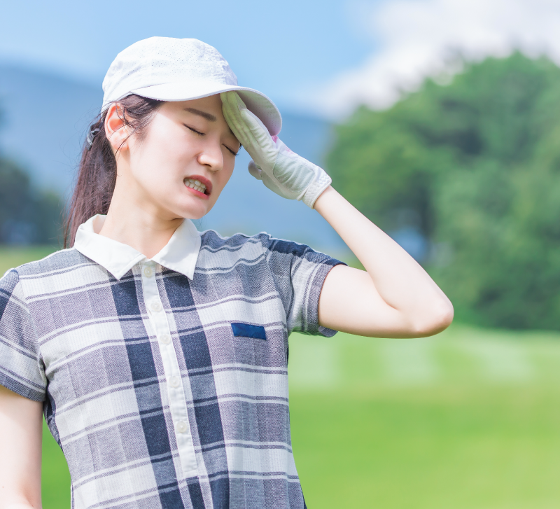 暑い日の外でゴルフをする人